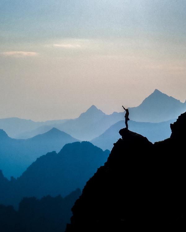 Person at the top of a mountain reaching their optimum